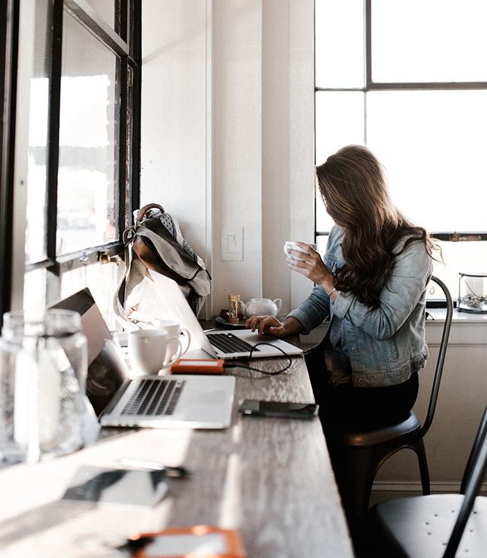 A woman working on a laptop at a coffee shop | Business Savers