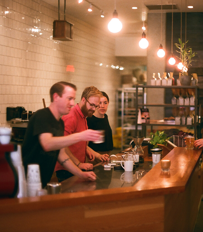 Cafe owner serving coffee to customers