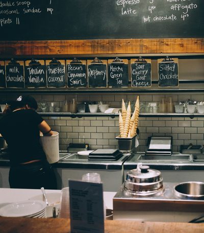 A woman serving food in an ice cream store | Business Savers