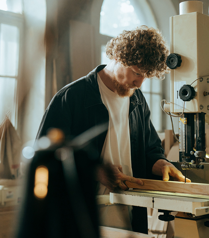 Carpenter cutting timber in workshop