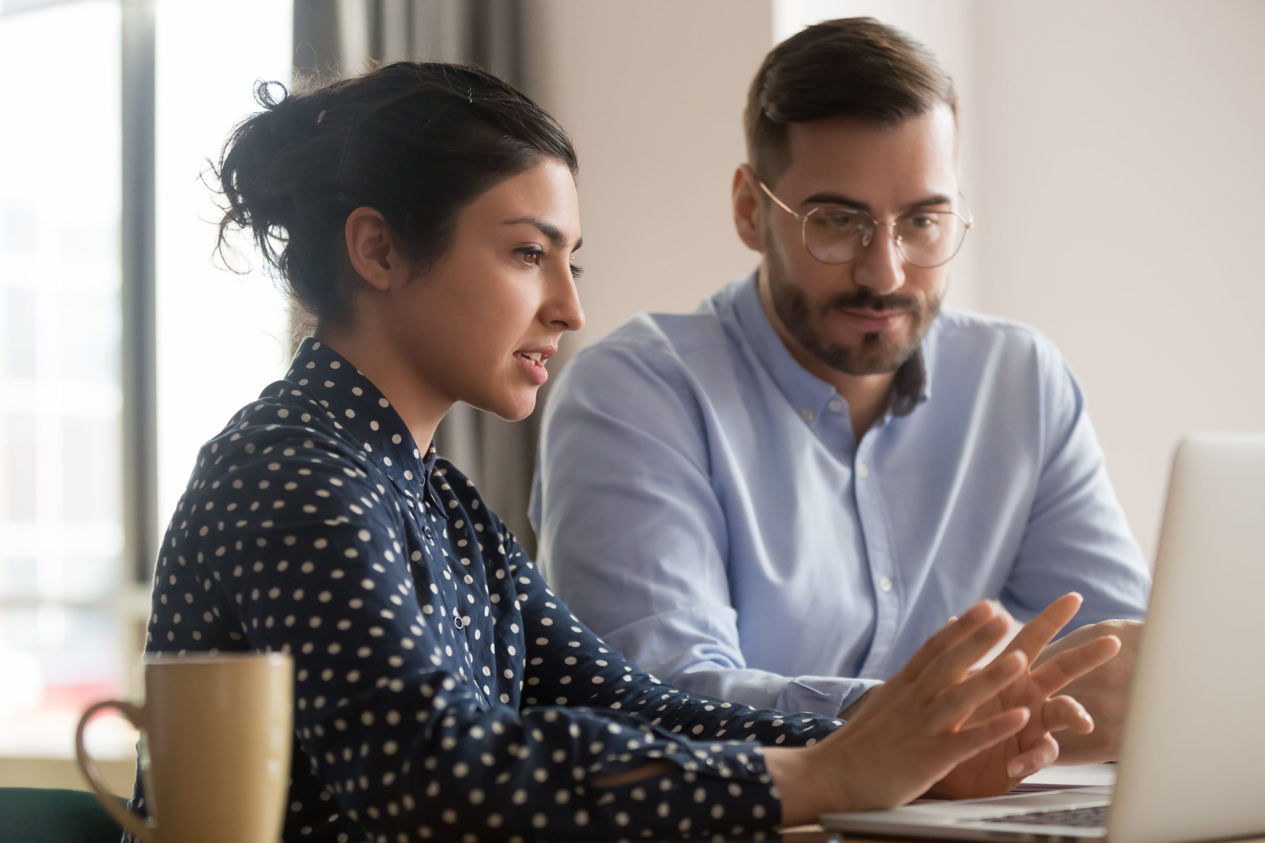 A man and woman at a laptop having a conversation | Business Savers